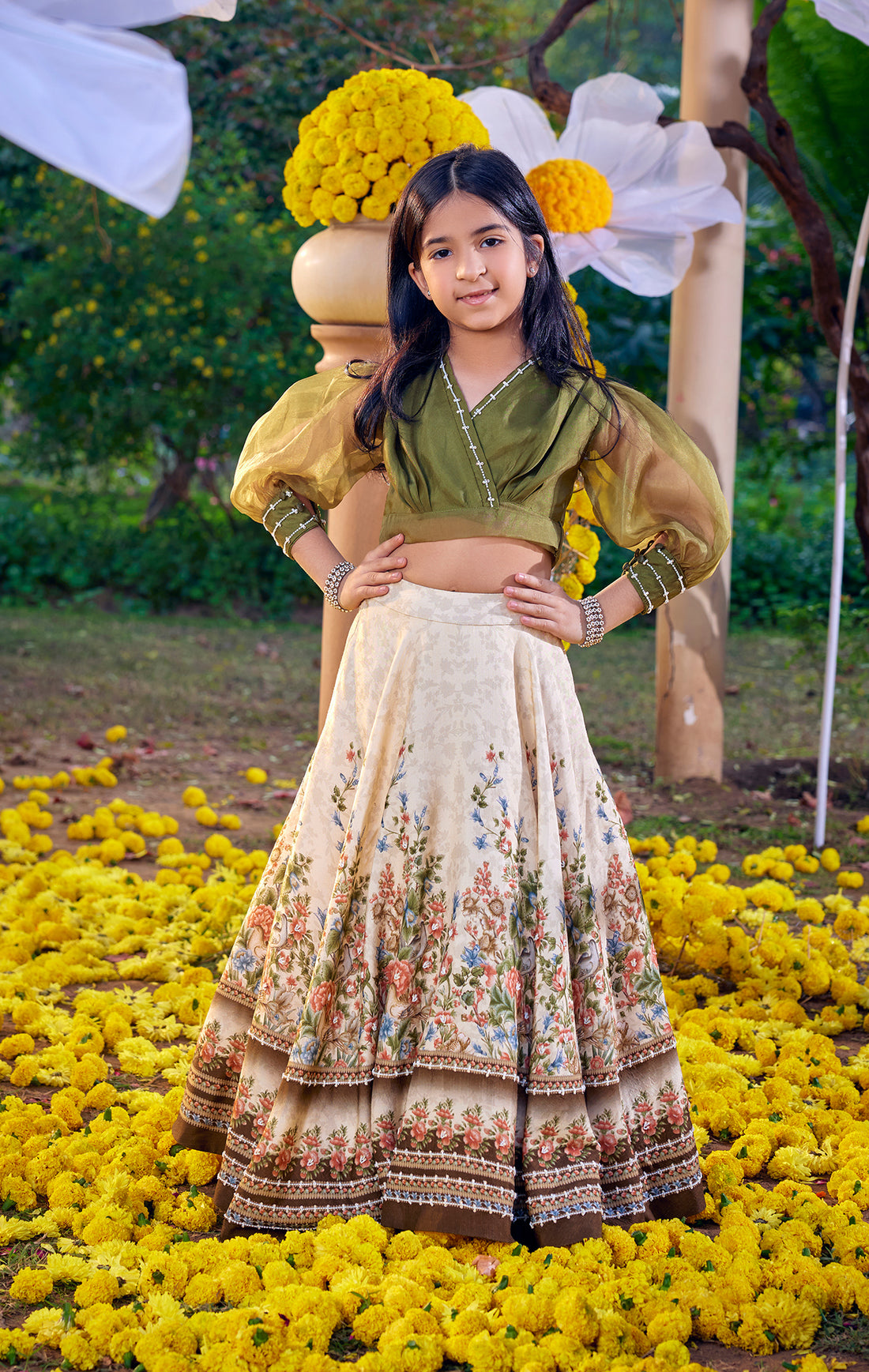 Family dressing is having a real moment this Diwali — coordinated palettes across generations, not identical outfits. Kalista's Amelia Vintage Lehenga Set , ivory and green viscose