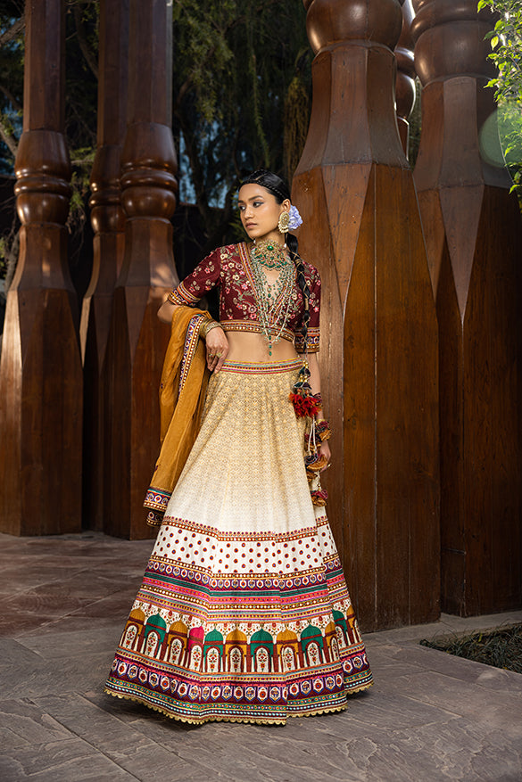 Hand-painted Mughal minaret motifs with intricate hand embroidery Meticulously crafted blouse with thread work and beadwork on yoke and sleeves Styled with a coordinated dupatta in natural silk and organza